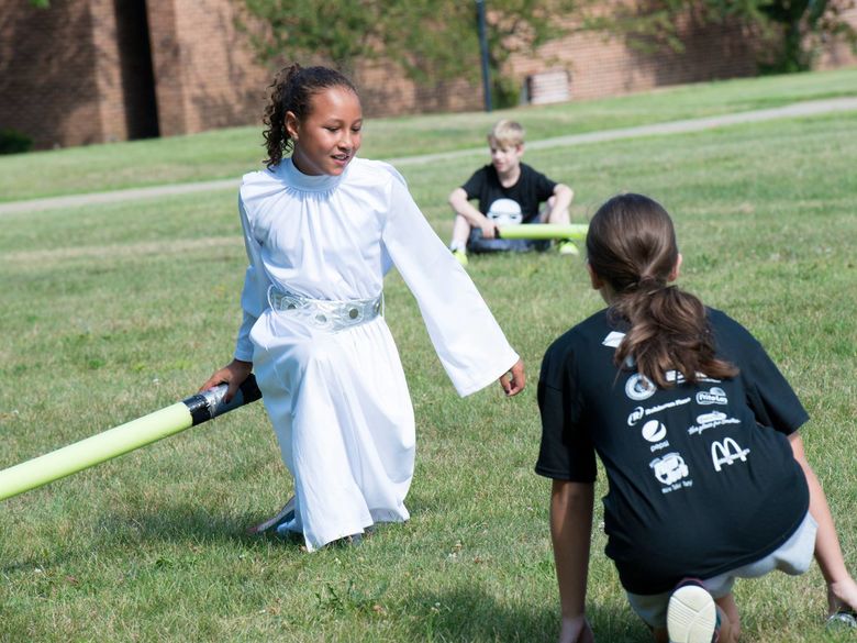 A student wields a light saber during a youth camp.